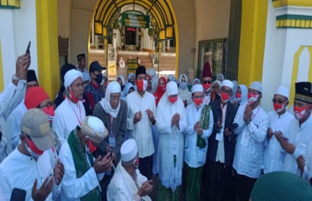 Foto: Pasangan Fauzi-Eva saat membacakan shalawat di depan pintu utama Masjid Jamik Sumenep