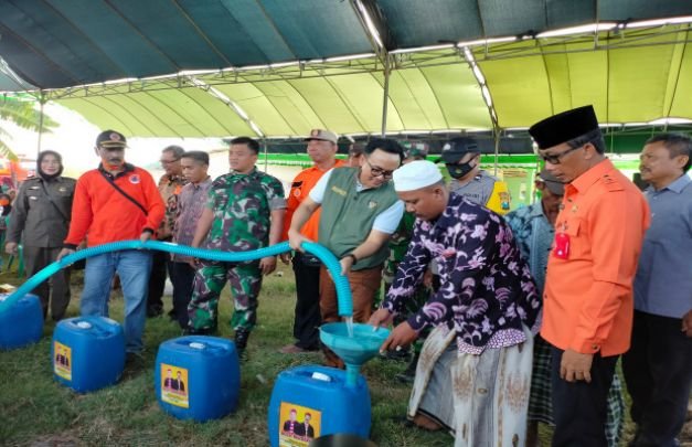 Foto : Bupati Pamekasan (pakai rompi) saat memberinkan langsung bantuan air bersih yang dibawa oleh tangki BPBD Kabupaten Pamekasan kepada warga Desa Jarin, Kecamatan Pademawu, Pamekasan Jawa Timur. Sabtu (24/9/2022).