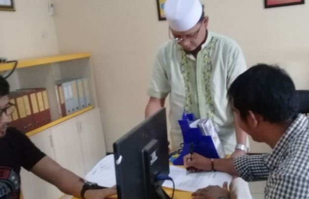 Foto: Agus Susanto, Wartawan Surabayapost.co.id saat menandatangani bukti laporan dari SPKT Polres Batu