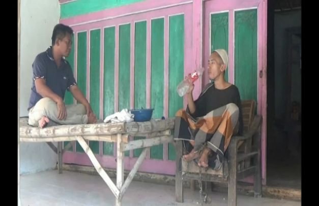 Foto : Aziz sebelah kanan, kakinya dipasung karena sering meresahkan warga sekitar