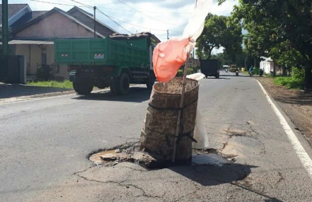 Foto: jalan rusak dan berlubang yang dipasangi oleh warga